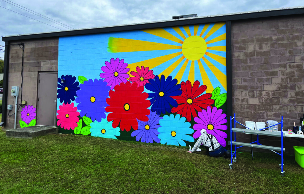 Artist adds sunshine and flowers to Clemmons building Davie County